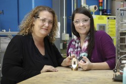 ORNL’s Bianca Haberl and Amy Elliott hold 3D printed collimators next to a pressure cell loaded with a sample. These collimators were developed as a collaboration between the lab’s Neutron Sciences Directorate and Manufacturing Demonstration Facility. (Image credit: ORNL/Genevieve Martin)