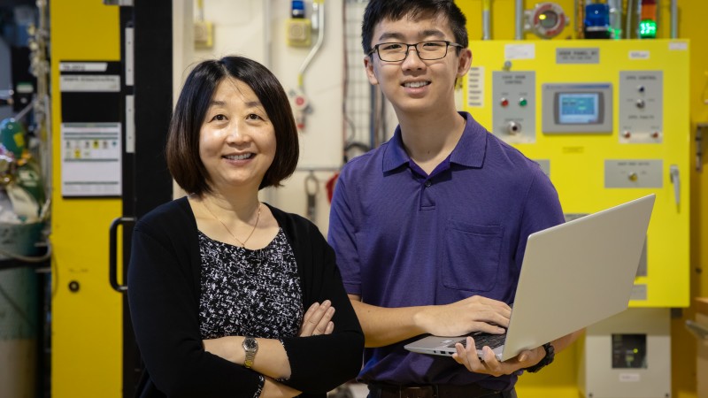 Corning Incorporated senior research scientist Ying Shi (left) uses neutron scattering to understand the structure–property correlation in glass to make new compositions. Her son, Albert Song (right), wrote data analysis code for her project and joined her on a recent visit to the Spallation Neutron Source. Credit: Genevieve Martin/Oak Ridge National Laboratory, U.S. Department of Energy.