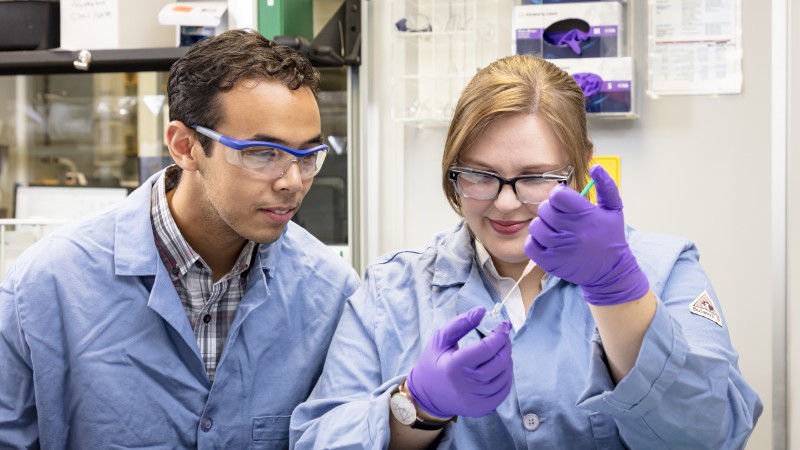 Caltech researchers Orland Bateman (left) and Rachel Ford prepare samples before using neutrons to study a novel form of mixed matrix membrane. (Credit: ORNL/Carlos Jones)