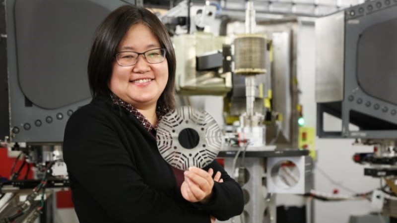 GE researcher Min Zou holds a metal laminate sheet made from a novel magnetic material used in a GE's prototype synchronous reluctance motor. Credit: ORNL/Genevieve Martin