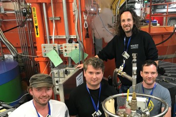 Standing at the WAND2 instrument, researchers (from left to right) Michael Heere and Yaroslav Filinchuk with ORNL beamline scientists Matthias Frontzek and Simon Kimber. (Image credit: ORNL/Jeremy Rumsey)