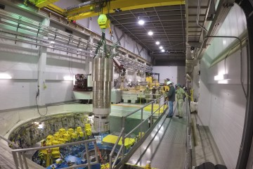A heavy overhead crane is used to lower the 64,000-pound inner reflector plug into position, right in the heart of the Spallation Neutron Source. (image credit: ORNL/Genevieve Martin)